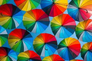 outdoors decoration with many colorful umbrellas against blue sky and sun photo