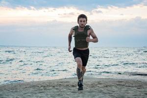 joven atleta barbudo entrenando al aire libre con chaleco ponderado, ejercicio con portador de placa militar