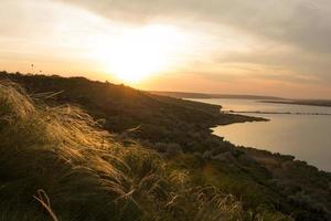 beautiful summer landscape with lake, hills and sunset photo