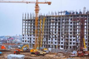 Concrete building in progress with cranes photo