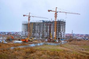 Concrete building in progress with cranes photo