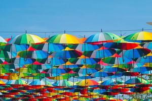 outdoors decoration with many colorful umbrellas against blue sky and sun photo