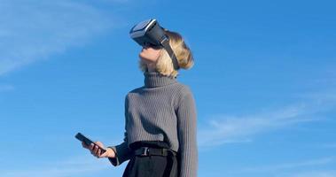 Young handsome female with virtual reality glasses outdoor on the beach against sunny blue sky photo