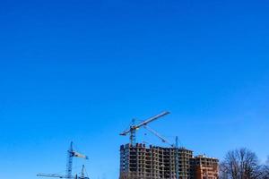 Concrete building in progress with cranes photo