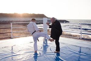 karate fighters are fighting on the beach boxing ring in morning photo