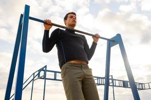 Young fit male training do exercises outdoor on the beach photo