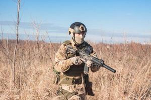 Airsoft Soldiers in posing with rifle in fields photo