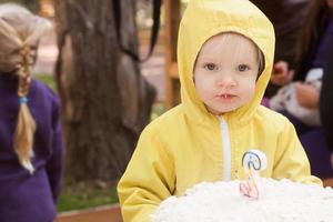 two years funny girl with birthday cake celebrates outdoors photo