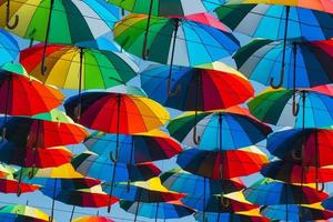 outdoors decoration with many colorful umbrellas against blue sky and sun photo