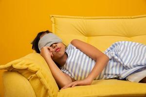 Asian child sleeping on a sofa with sleep mask. photo