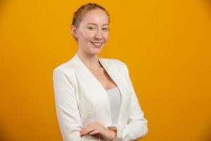 Young, confident, successful and beautiful business redhead woman on yellow. Occupation, career, job concept. photo