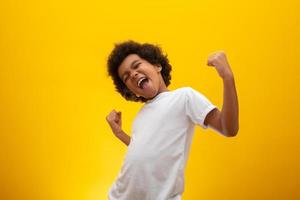 African American boy with black power hair on yellow background. Smiling black kid with a black power hair. Black boy with a black power hair. African descent. photo