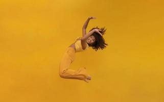 Side view of afro hair woman in zero gravity or a fall. Girl is flying, falling or floating in the air. Side view of person. Over yellow background. Getting sucked up. Woman being abducted. photo