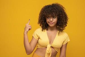 Are you out of your mind Horizontal shot of handsome emotional Afro American woman fore finger at his temple. Making fun of crazy idea. Body language, signs and gestures. photo