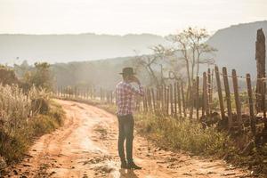 Farmer or country man using a smartphone on the farm. Internet 4G farmer. Social networks, online consultations. photo