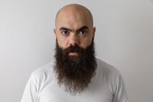 Bearded man looking at the camera. Concept of masculinity and care with the beard. Pointing with finger, approving or indicating. photo