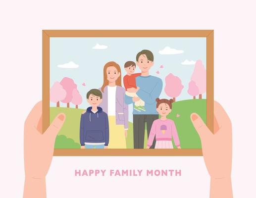 happy family photo. A hand holding a picture frame.