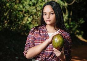 Young girl holding avocado in a shape similar to a heart. Avocado is a low fat food. photo