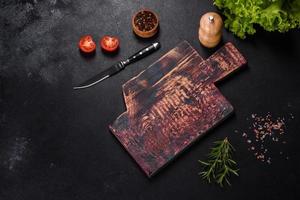 A wooden cutting board with a kitchen knife with spices and herbs photo