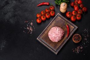 Ground meat with ingredients for cooking on black background photo