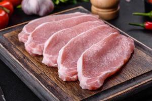 carne de cerdo fresca cruda cortada en una tabla de cortar de madera