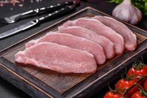 Raw fresh pork meat sliced on a wooden cutting board photo