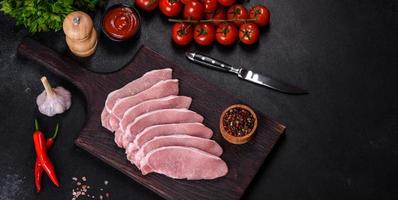 Raw fresh pork meat sliced on a wooden cutting board photo