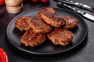 Fish cakes. Fish patties. Fried cutlets of minced fish on a black plate photo