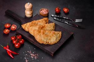 Homemade chebureks filled with minced meat and onions, traditional Caucasian cuisine photo