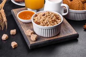 Delicious nutritious healthy breakfast with granola, eggs, oat cookies, milk and jam photo