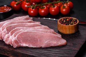 Raw fresh pork meat sliced on a wooden cutting board photo