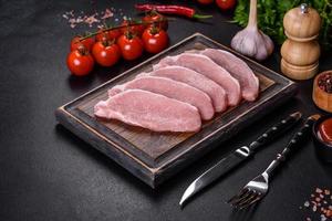 carne de cerdo fresca cruda cortada en una tabla de cortar de madera