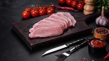 Raw fresh pork meat sliced on a wooden cutting board photo
