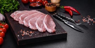 Raw fresh pork meat sliced on a wooden cutting board photo