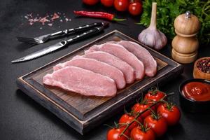 Raw fresh pork meat sliced on a wooden cutting board photo