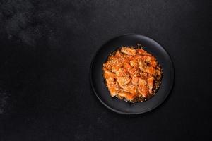 Teriyaki chicken with sauce, sesame, herbs and spices on a dark background photo