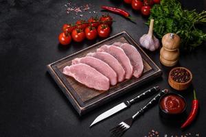 Raw fresh pork meat sliced on a wooden cutting board photo