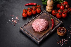 Ground meat with ingredients for cooking on black background photo