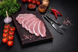 Raw fresh pork meat sliced on a wooden cutting board photo