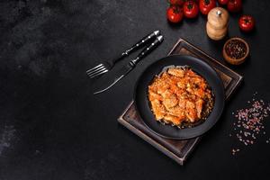 Teriyaki chicken with sauce, sesame, herbs and spices on a dark background photo