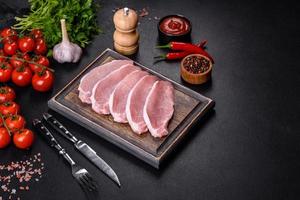 Raw fresh pork meat sliced on a wooden cutting board photo