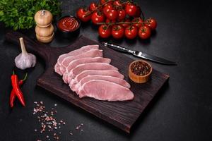 Raw fresh pork meat sliced on a wooden cutting board photo
