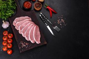 Raw fresh pork meat sliced on a wooden cutting board photo