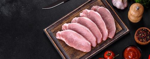 Raw fresh pork meat sliced on a wooden cutting board photo