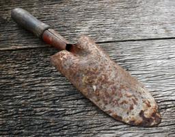 Small rusty shovel on wooden photo