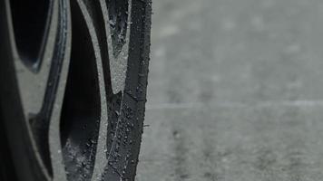 salpicos de chuva e pneu de carro na água da chuva. estacionamento na chuva. video