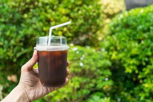 hand holding iced black coffee or americano coffee photo