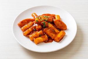 Korean rice cake stick with sausage in spicy sauce - Tteokbokki photo