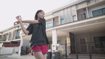 Asian woman doing shoulder arms stretching before exercise ,muscle injury prevention, heating up body before running, human metabolism and immune system, outside neighborhood street exercising routine video