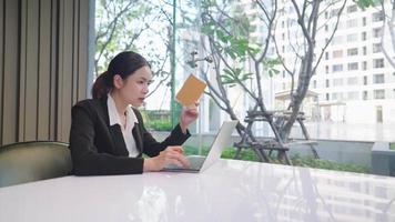 Aantrekkelijke overstuur Aziatische zakenvrouw met werkende obstakels, jonge werknemer concentreert zich op het denken op laptop computerscherm, lost een online probleem op of doet onderzoek aan bureau